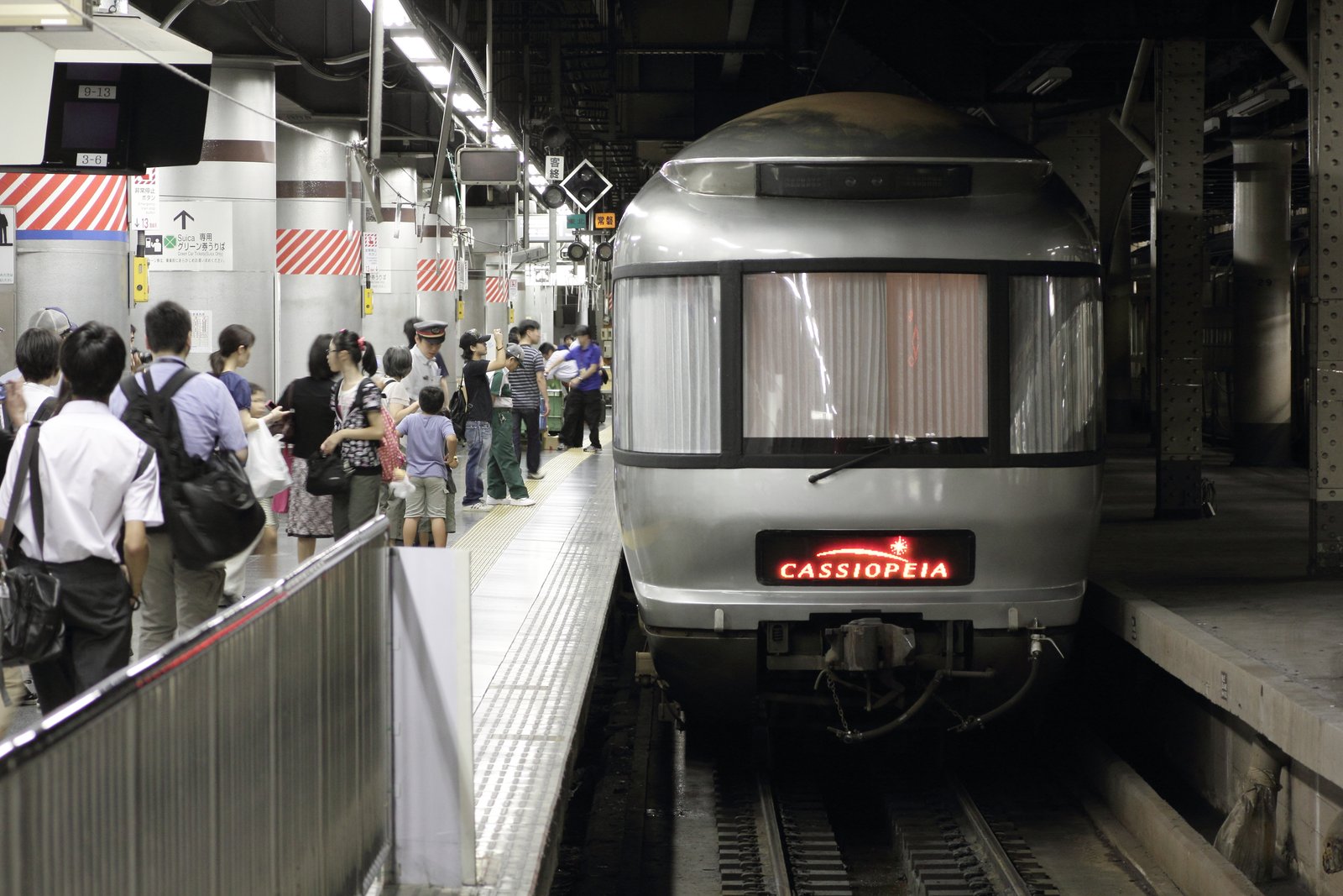 上野駅の地平ホームに停車する銀色のカシオペア。丸みのある先頭に大きな窓とカーテン、赤く光る CASSIOPEIA の表示がある