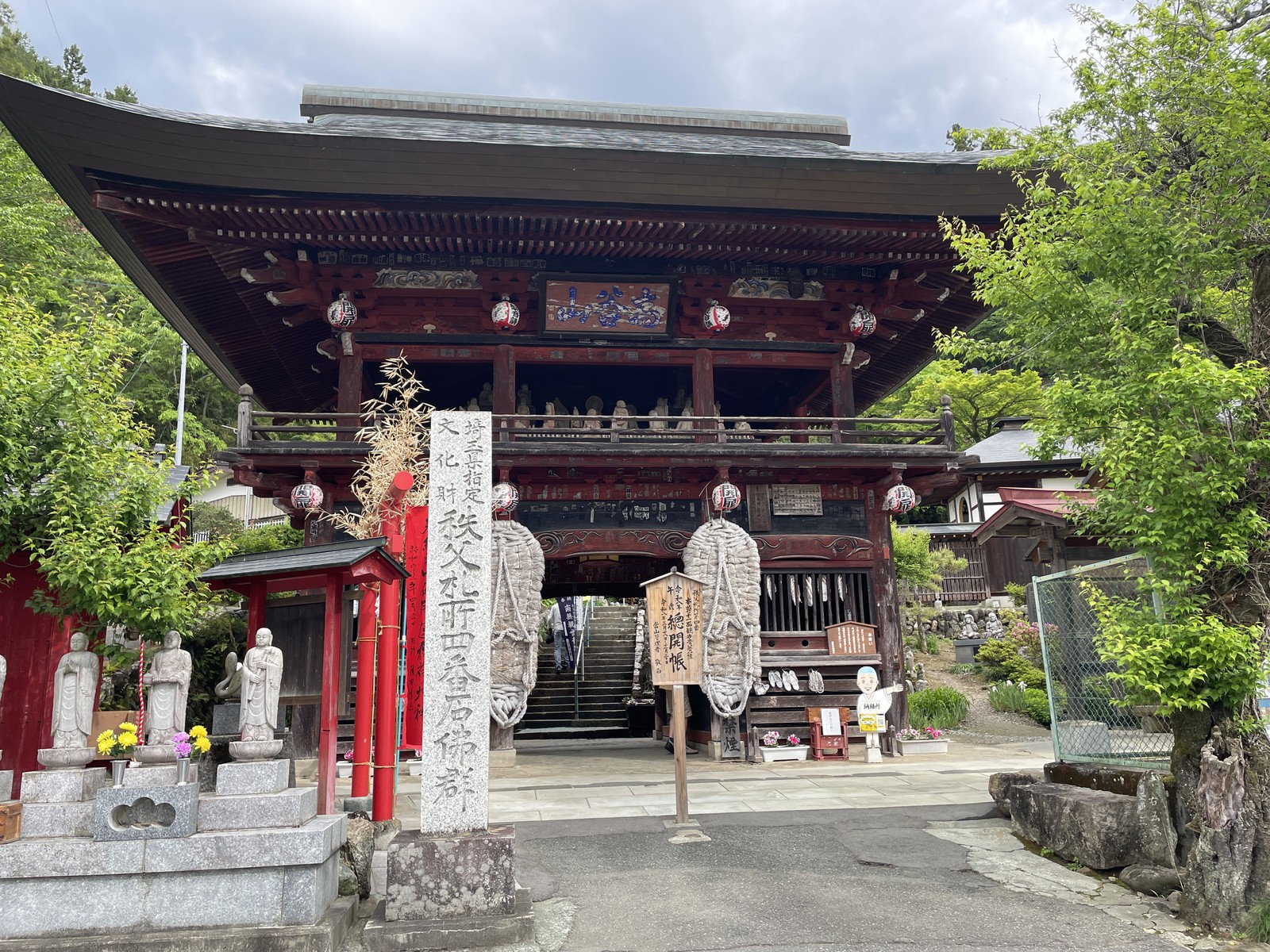 埼玉県秩父市の金昌寺（秩父札所4番）の仁王門。大わらじが掛かった楼門造りの山門で、手前に石仏が並ぶ