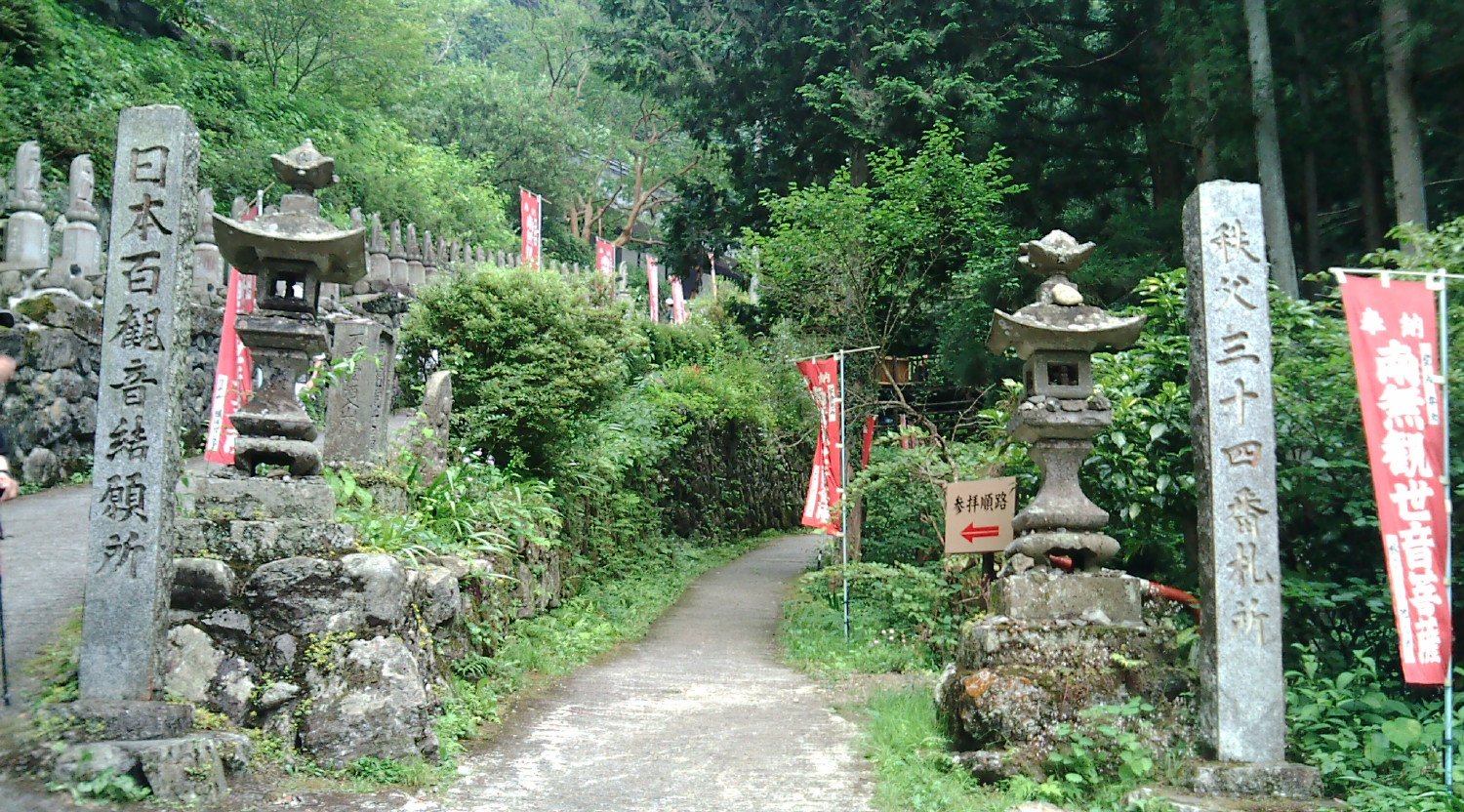 秩父札所34番 水潜寺の入口。「日本百観音結願所」「秩父三十四番札所」の石柱と石灯籠が参道の両側に立ち、赤いのぼりが並ぶ