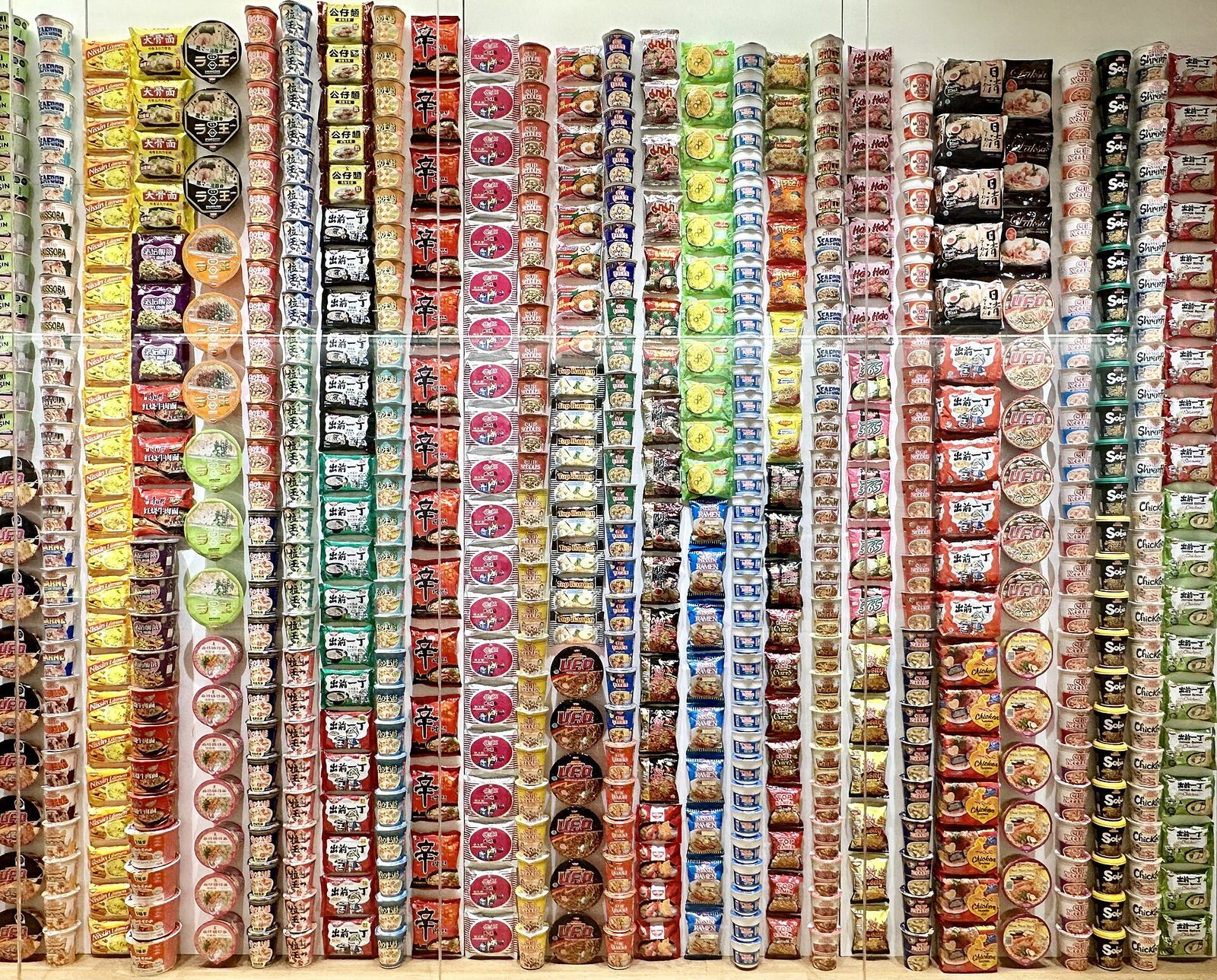 世界各国の即席麺のパッケージを天井近くまで積み上げて展示する棚