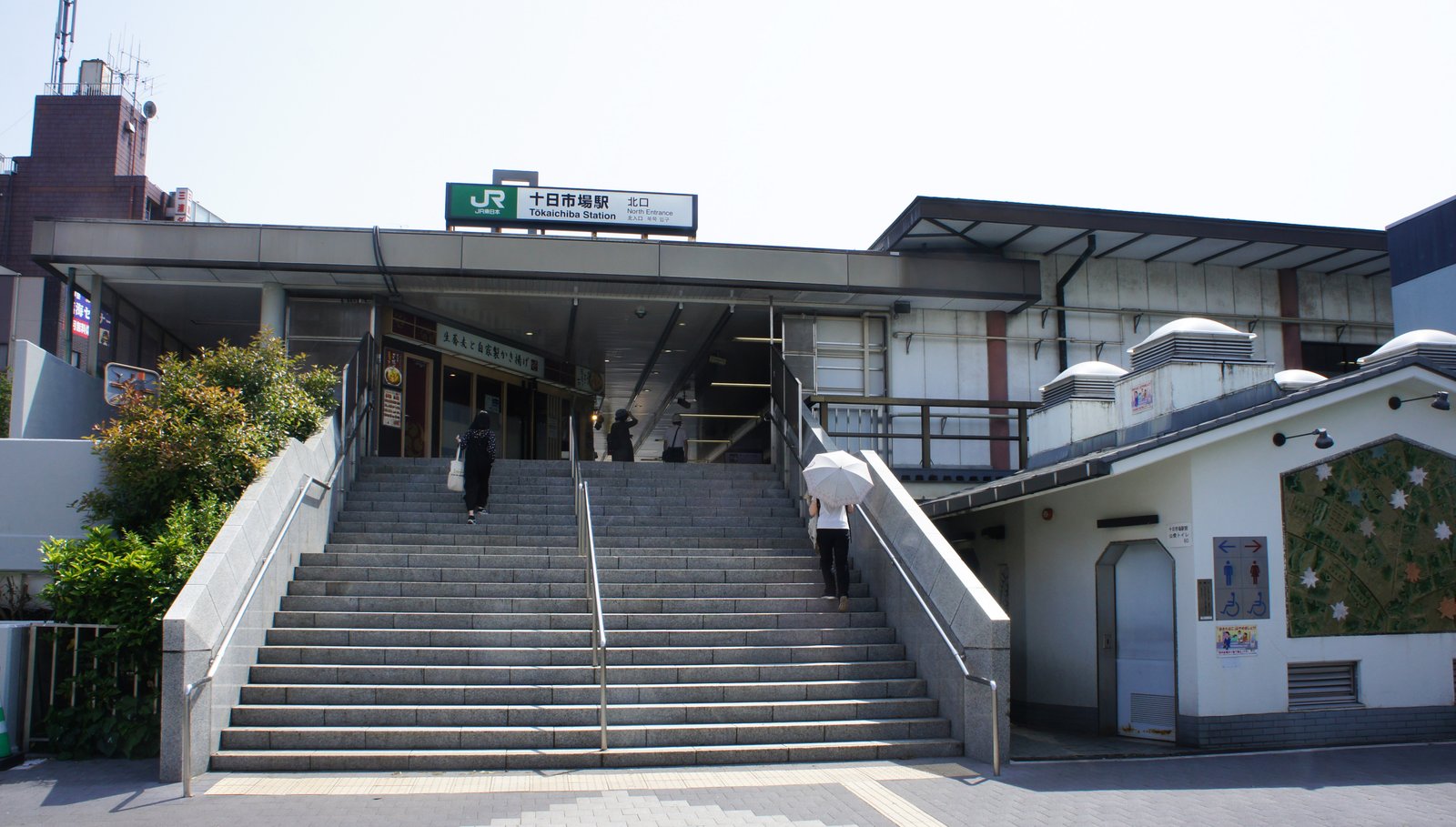 JR横浜線の十日市場駅の北口。駅名の看板の下に幅の広い石の階段があり、右手に公衆トイレの建物がある