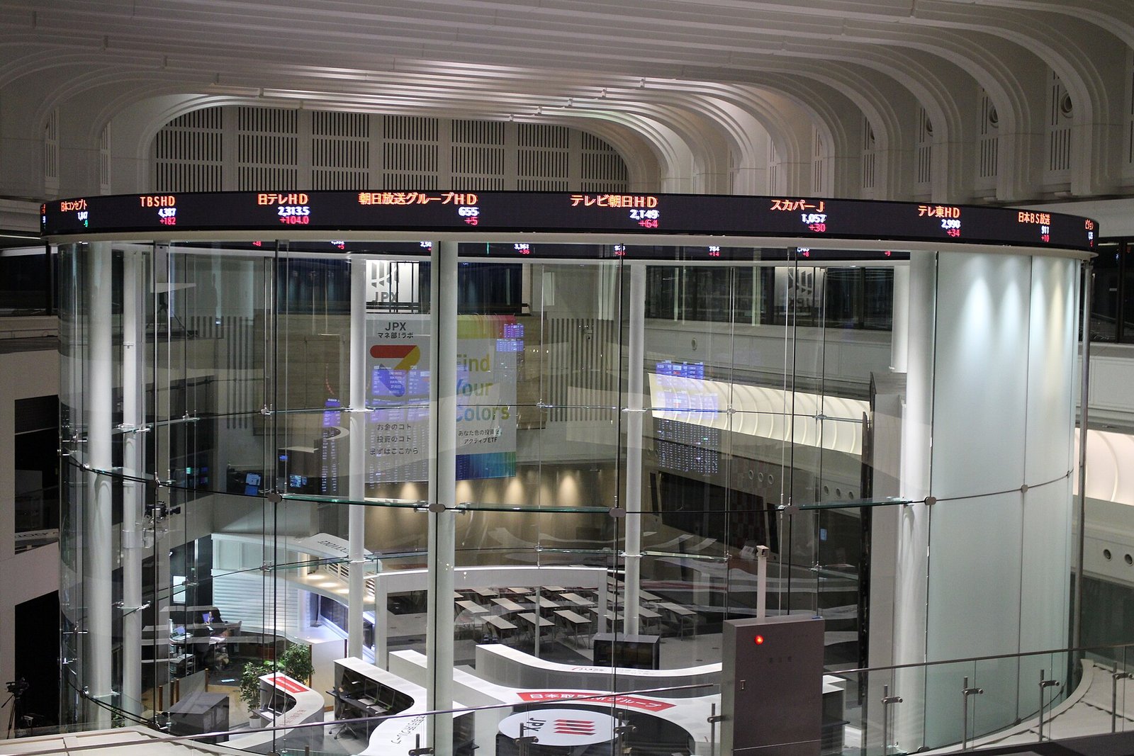 東証Arrowsのガラス張りの吹き抜け空間。株価表示のボードが壁を囲む