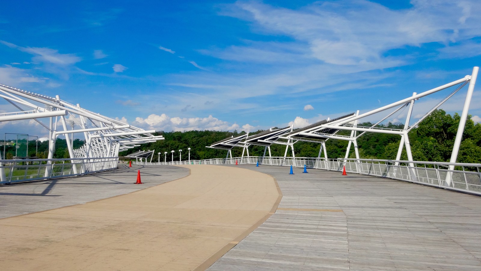 愛・地球博記念公園に残るグローバルループ。白い鉄骨の屋根が架かる木製デッキの遊歩道が緑の丘へ向かって続く