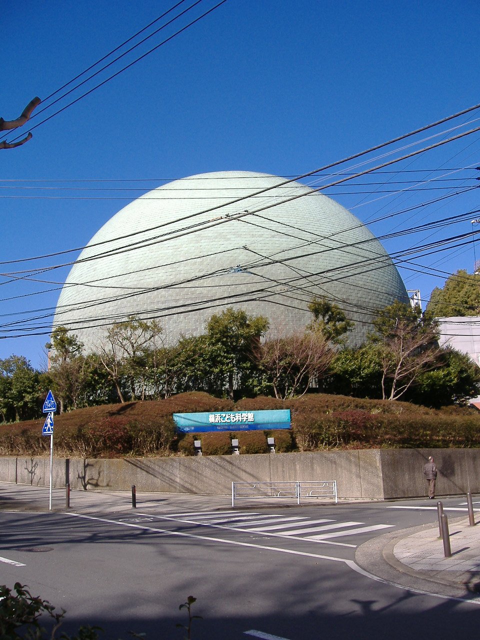 住宅街の向こうにそびえる、はまぎん こども宇宙科学館のドーム型プラネタリウム棟