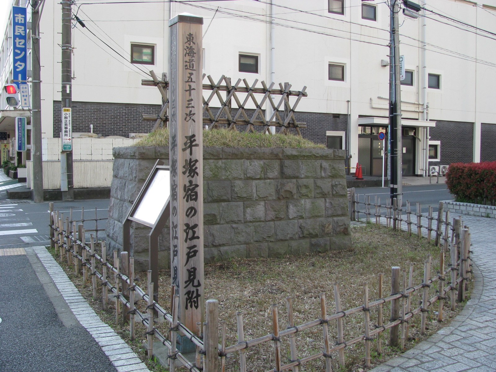 石積みの台の上に芝を植えた江戸見附の再現と、「東海道五十三次 平塚宿の江戸見附」と書かれた木の標柱、竹の柵
