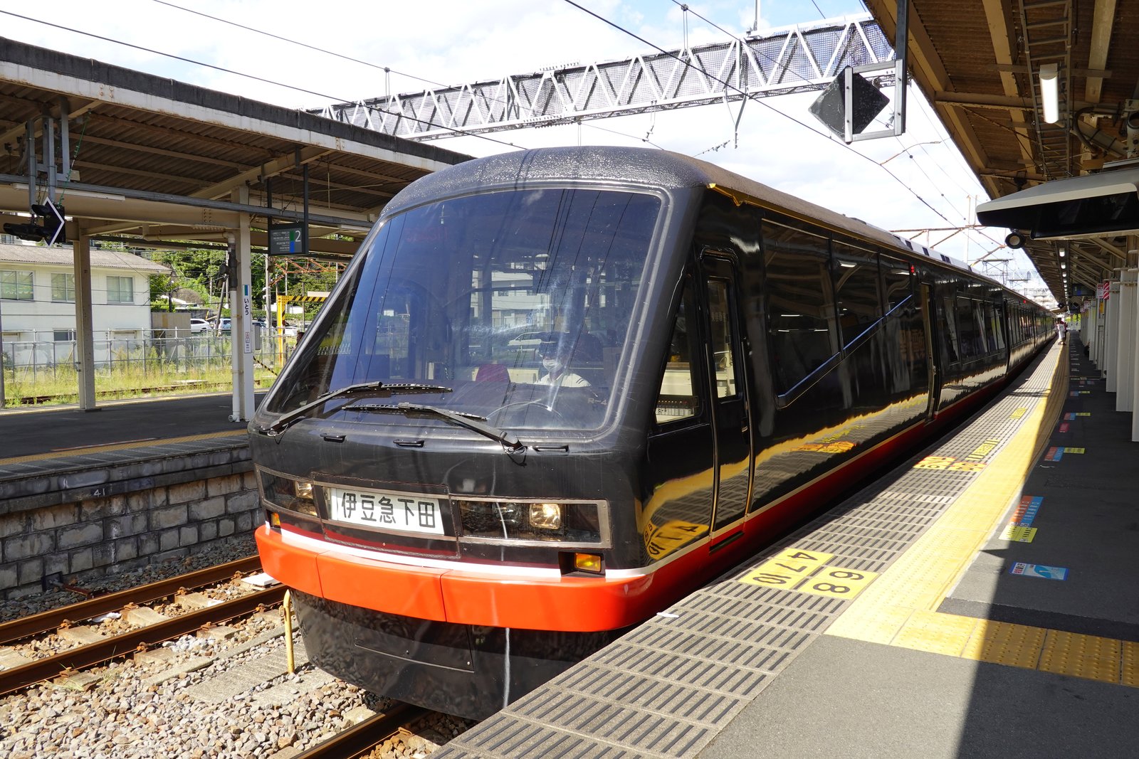 伊東駅のホームに停まるリゾート21の黒船電車。黒い車体に赤い帯が入り、前面の行き先表示は「伊豆急下田」
