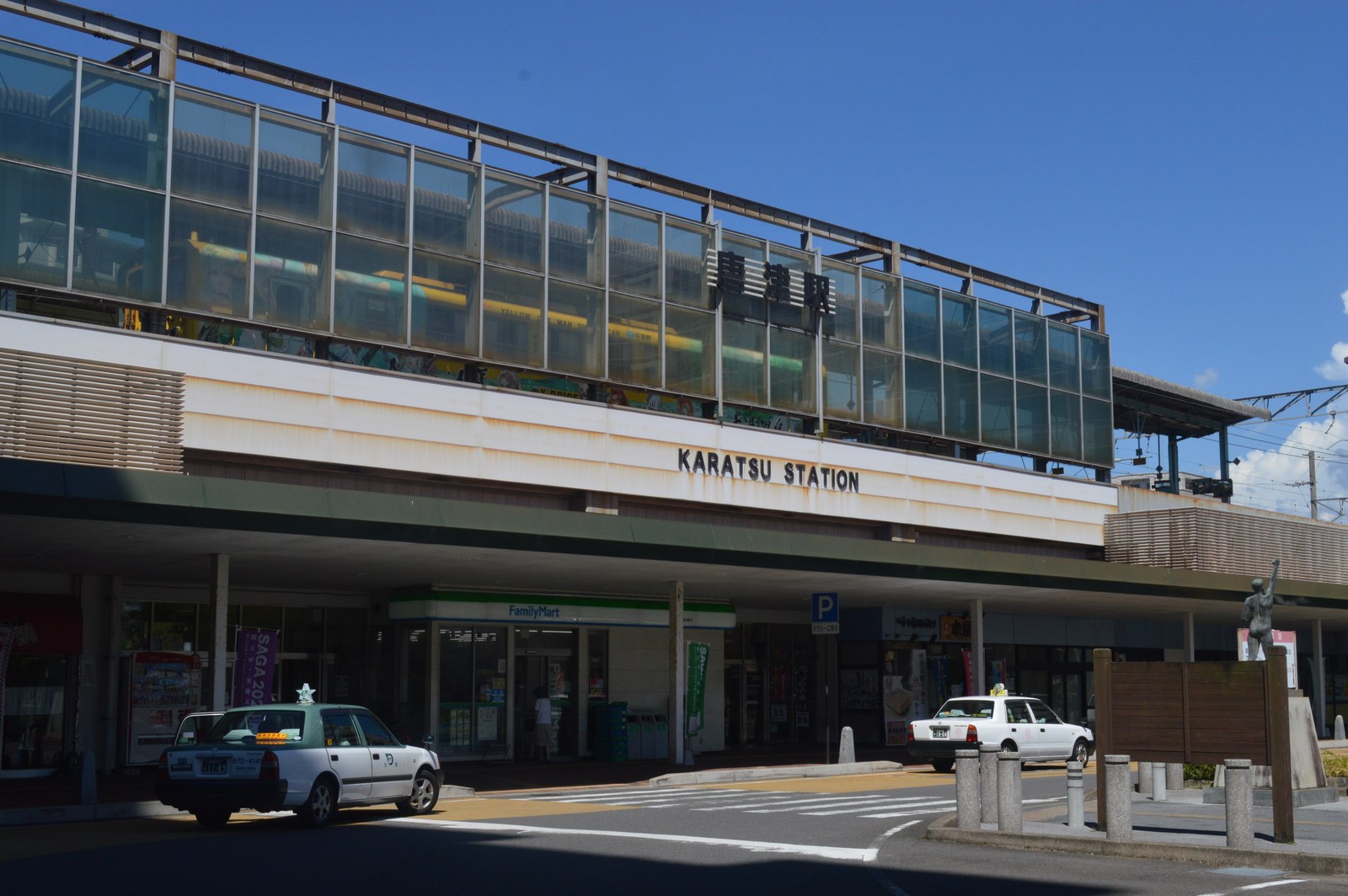 JR 唐津駅の駅舎。高架のホームの下に駅の入口があり、駅前にタクシーが停まっている