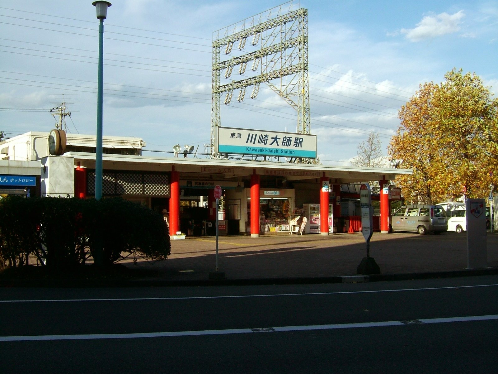 京急大師線の川崎大師駅。赤い柱の平屋の駅舎で、屋根の上に「京急 川崎大師駅」の看板が立つ