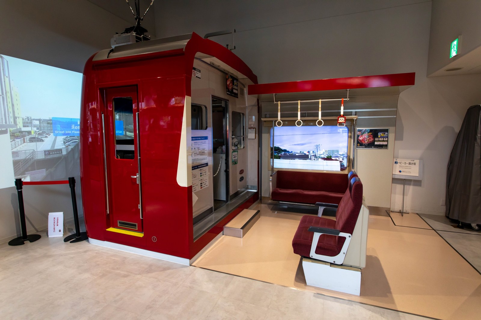 赤い車体の新1000形をかたどった鉄道シミュレーターの運転台と、隣の座席