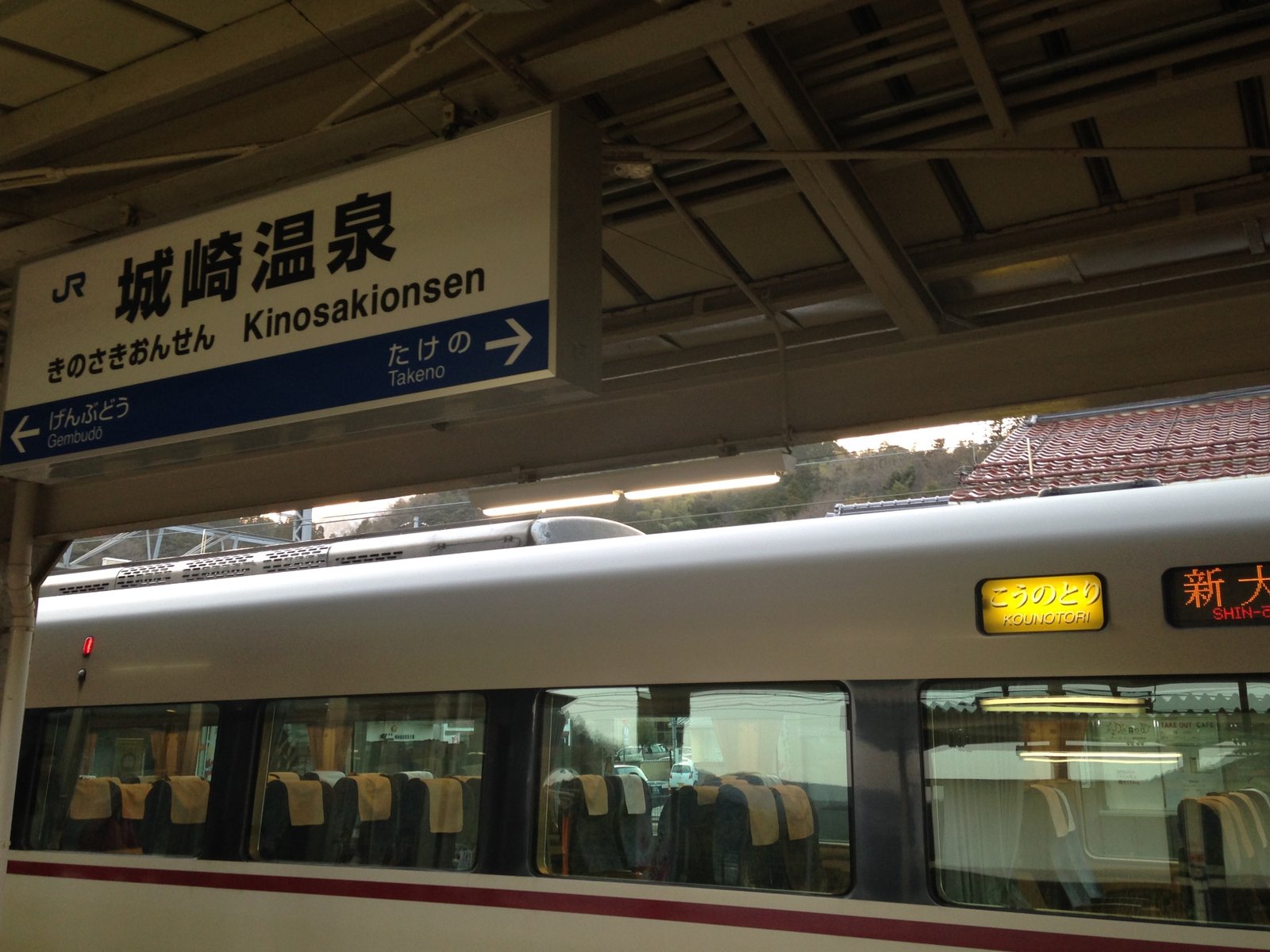 城崎温泉駅のホームにある「城崎温泉」の駅名標と、行先表示に「こうのとり」と出ている停車中の特急の車体