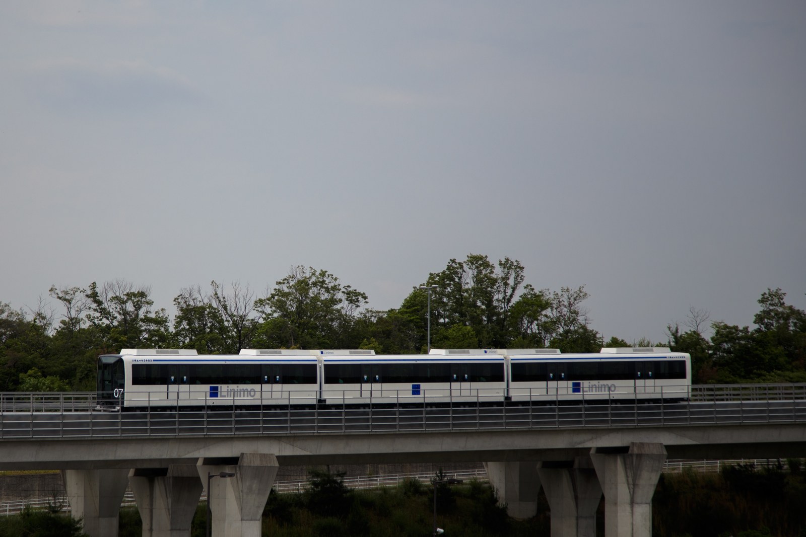 高架橋を走る愛知高速交通リニモの車両。白い車体に青いラインが入った磁気浮上式の列車