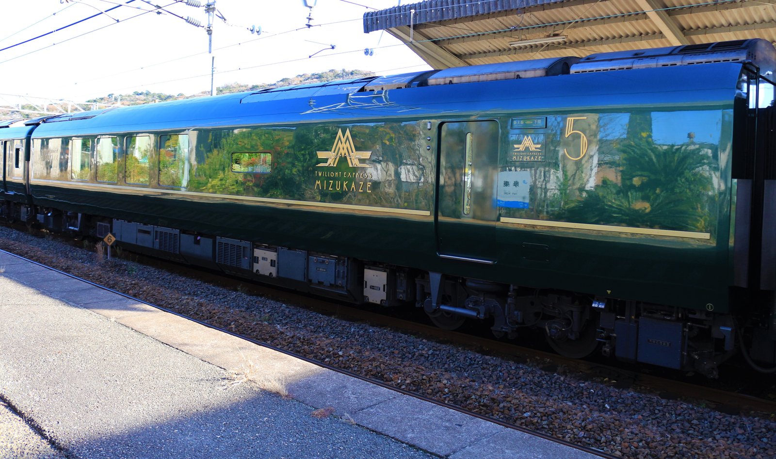 瑞風の5号車。深い緑色の車体に金色の TWILIGHT EXPRESS MIZUKAZE のロゴと数字の5が入る