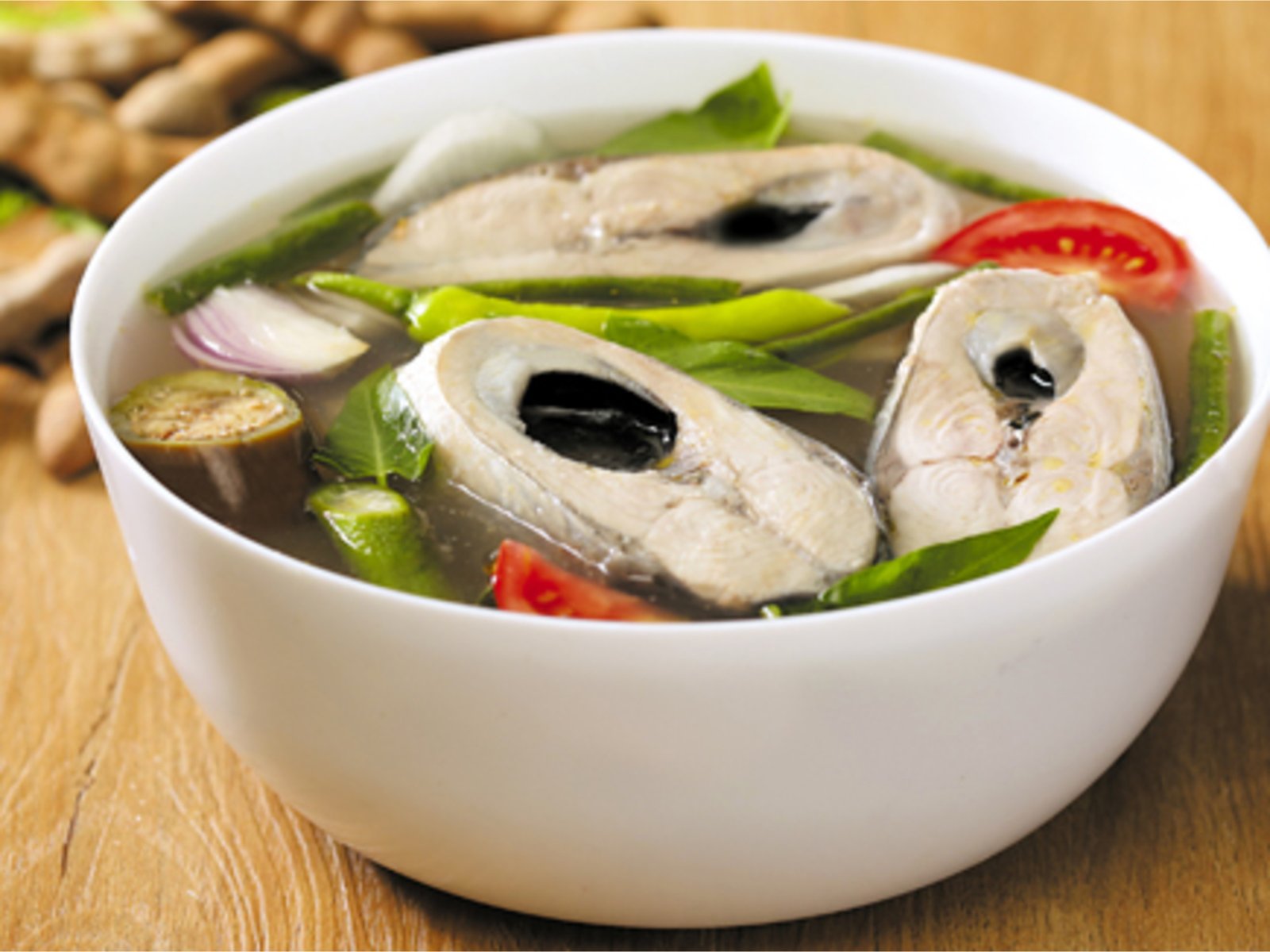器に盛った魚のシニガン。野菜と魚の切り身が入った透明なスープ