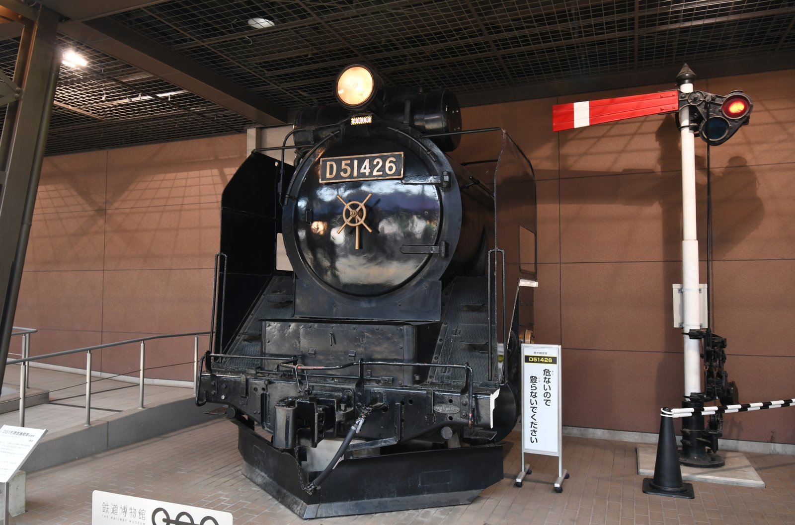 D51形426号機の前頭部。黒い車体に「D51426」のナンバープレートが付き、ヘッドライトが灯っている