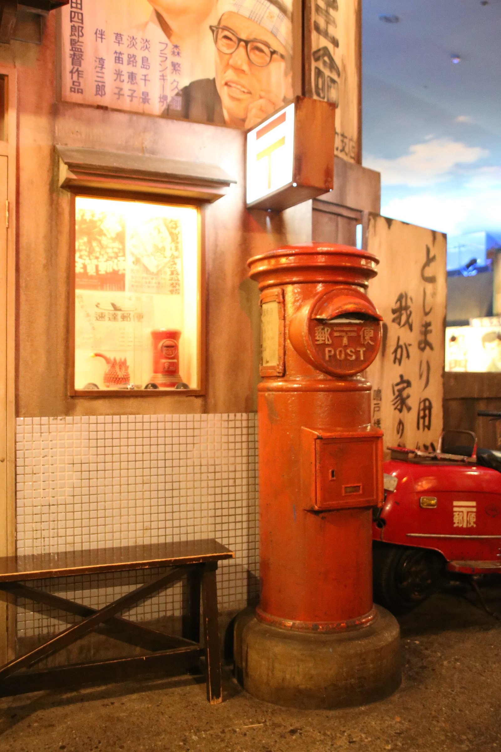館内の街並みの一角に置かれた赤い丸型郵便ポストの再現物