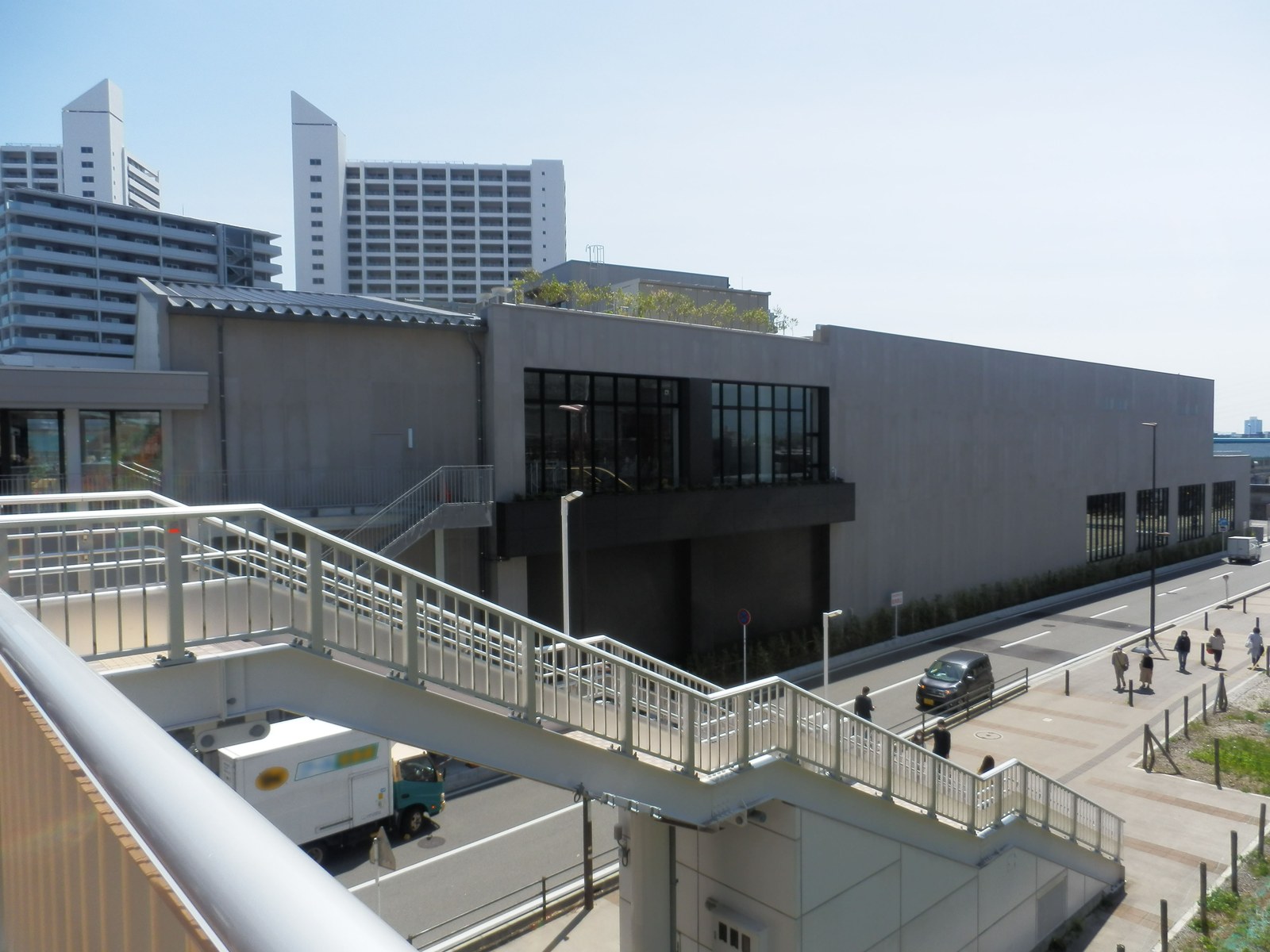 ロマンスカーミュージアムの外観。手前に海老名駅とを結ぶペデストリアンデッキの歩道橋、奥にコンクリート打ちっぱなしの建物