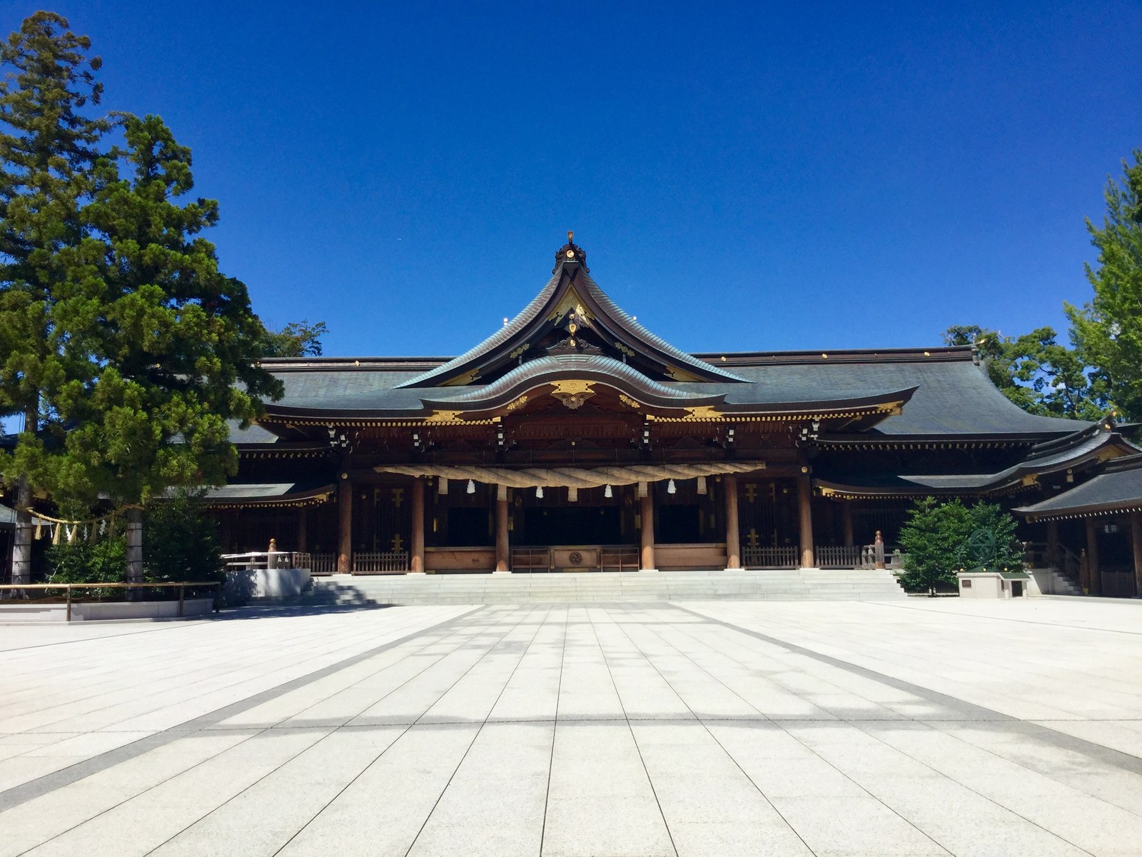 寒川神社の社殿。白い石畳の広い境内の奥に、太い注連縄を掛けた大きな屋根の拝殿が建っている