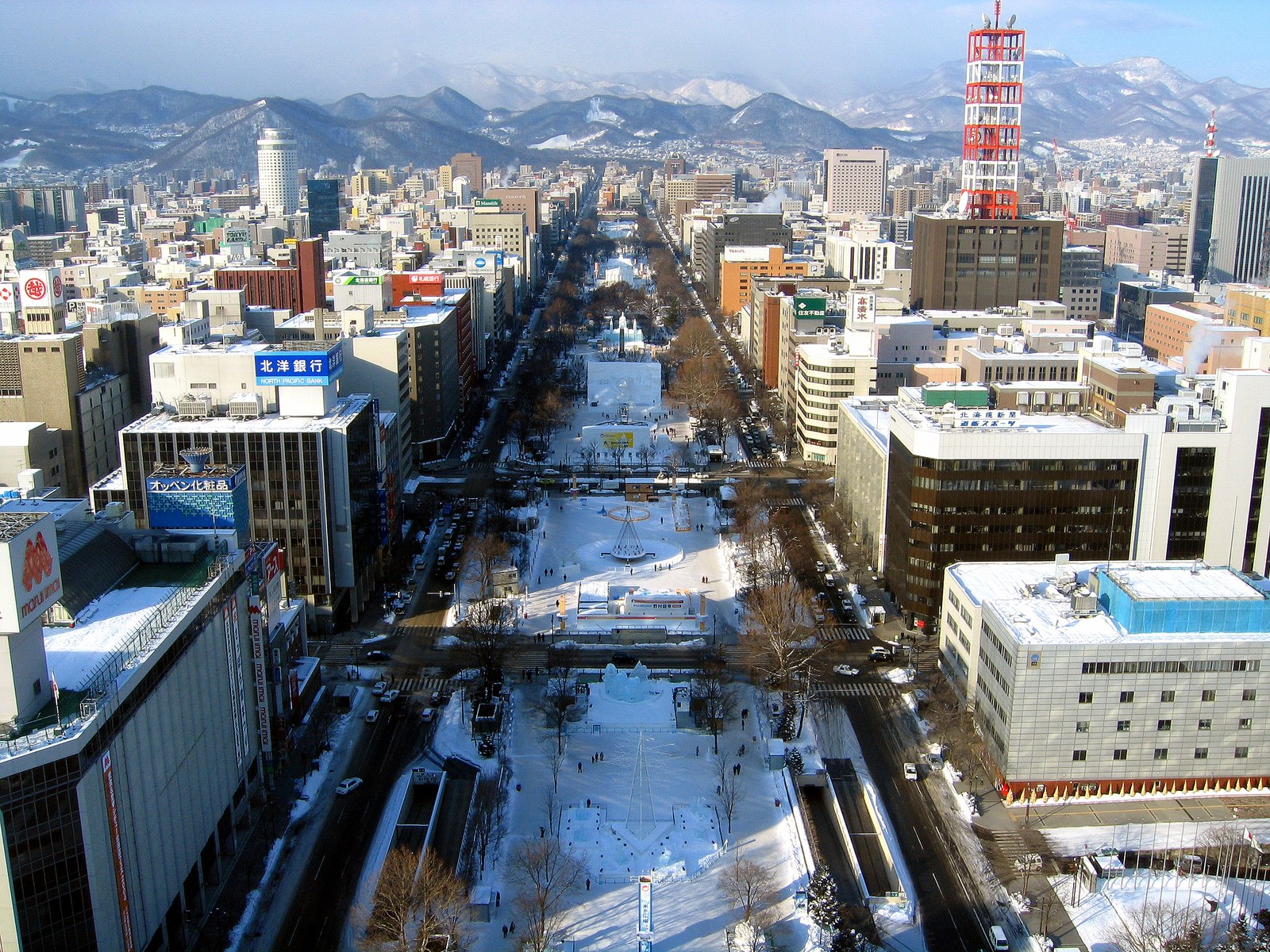 札幌の大通公園を高い所から見た冬の景色。雪の積もった細長い公園がビルの間をまっすぐ延びている