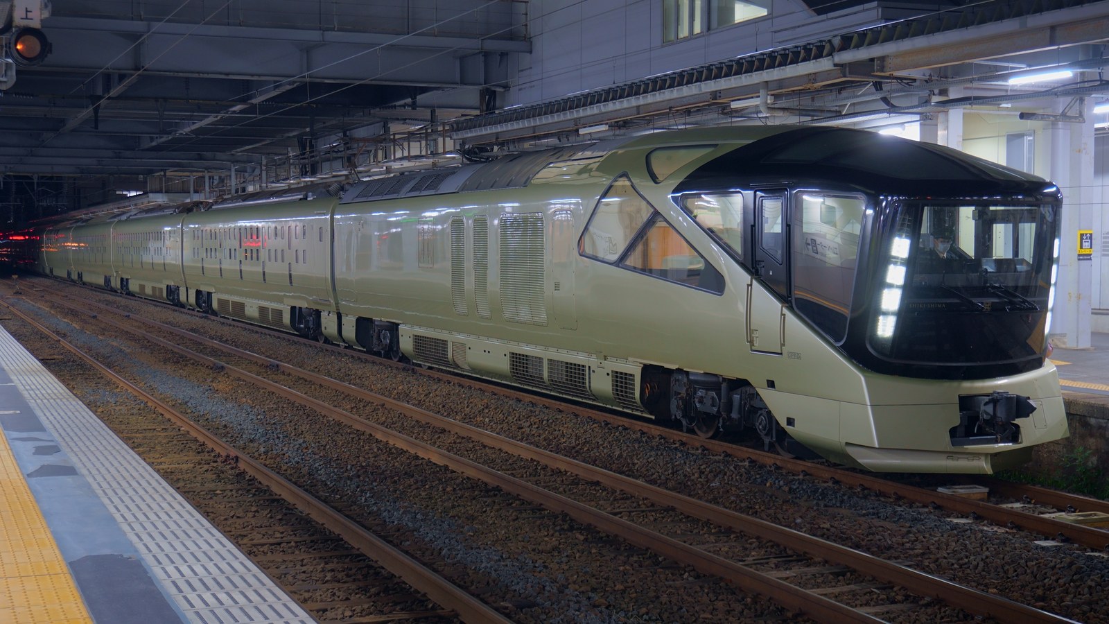 秋田駅に停車中のTRAIN SUITE 四季島（E001形）。シャンパンゴールドの車体で、先頭は大きく傾斜したガラス張りの展望窓