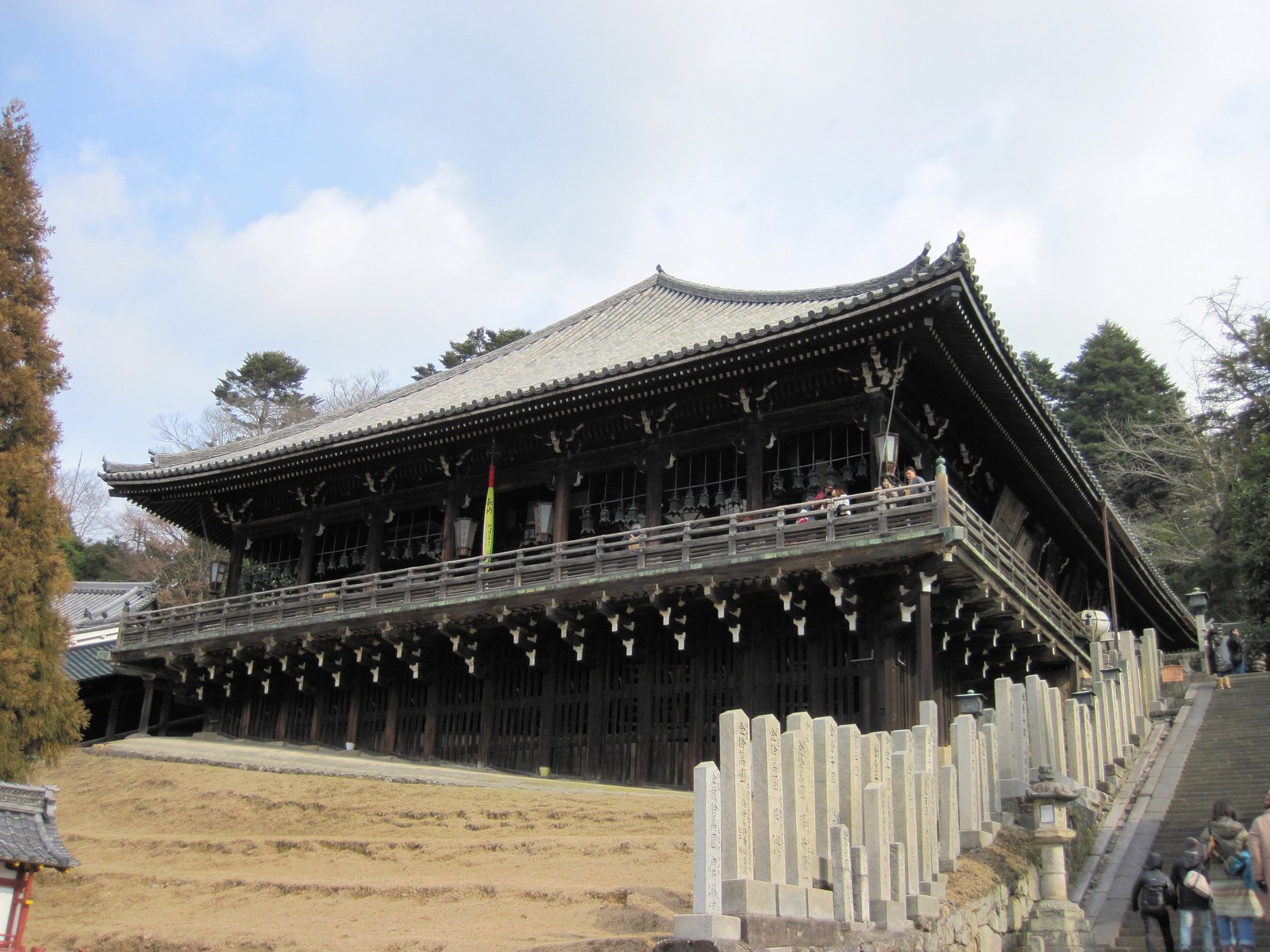 昼の東大寺二月堂。斜面に張り出した舞台を太い柱が支え、下に石段と石の玉垣が続く