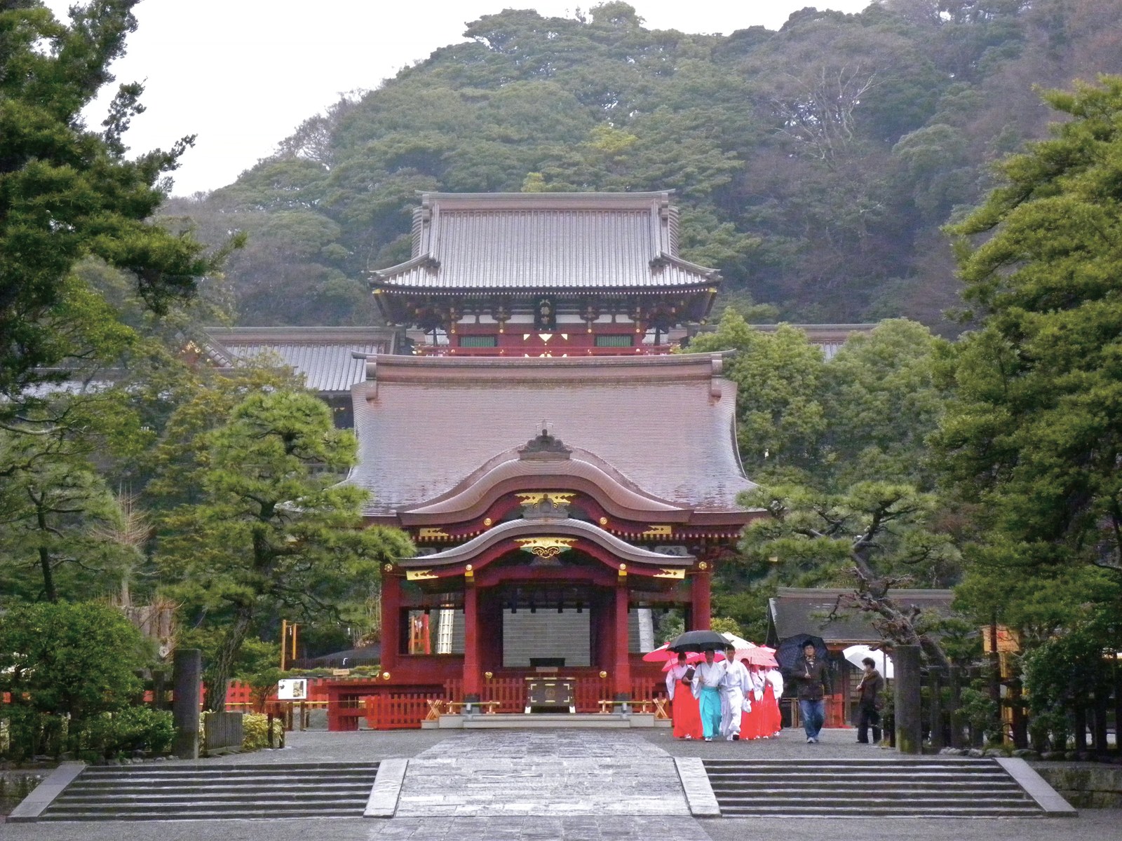 鶴岡八幡宮の舞殿と、その奥の石段の上に建つ本宮の楼門。背後は木の茂る山