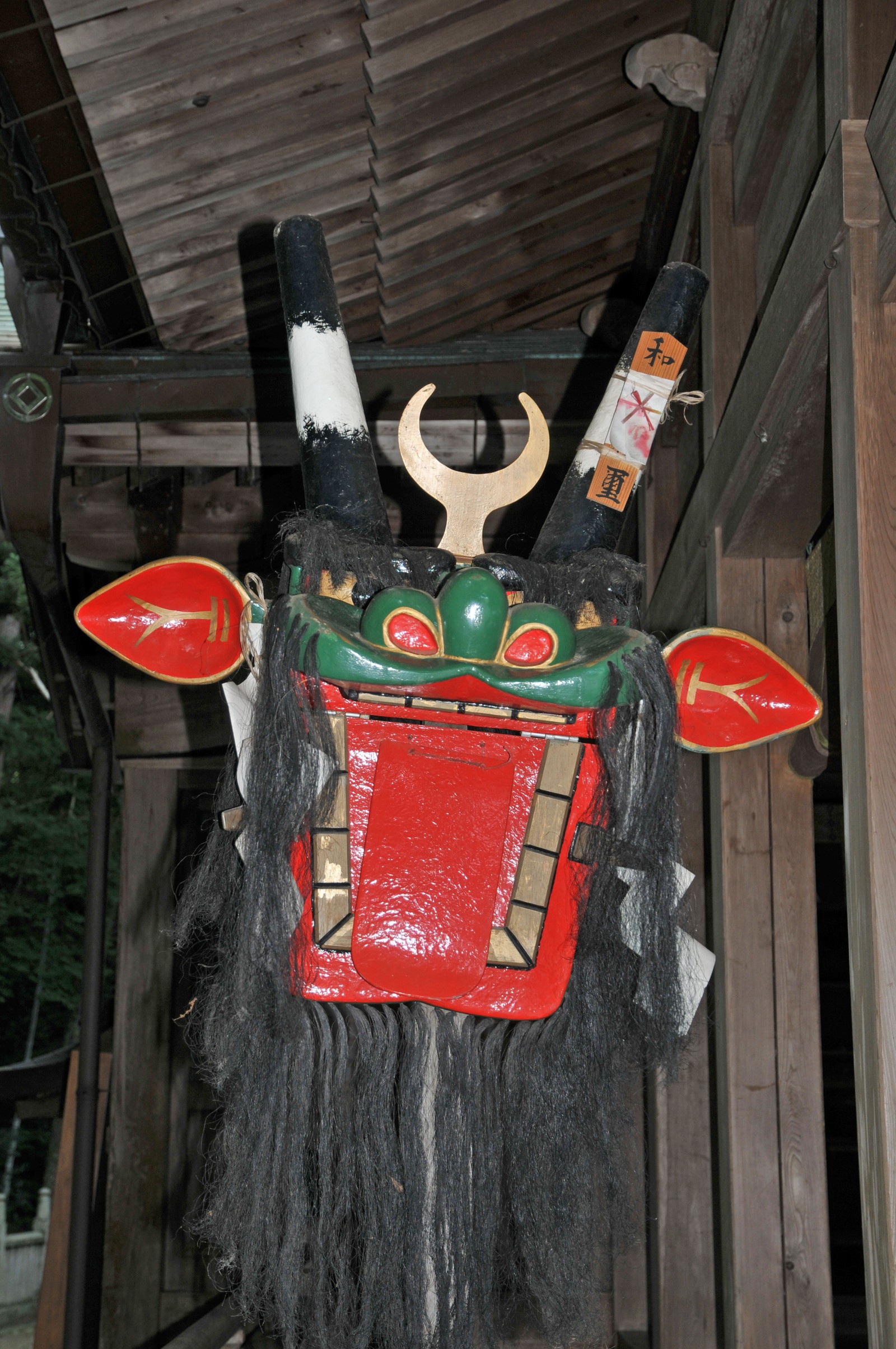 和霊神社の拝殿に安置された牛鬼の頭部。丸太の長い首と鬼面の頭部が写る