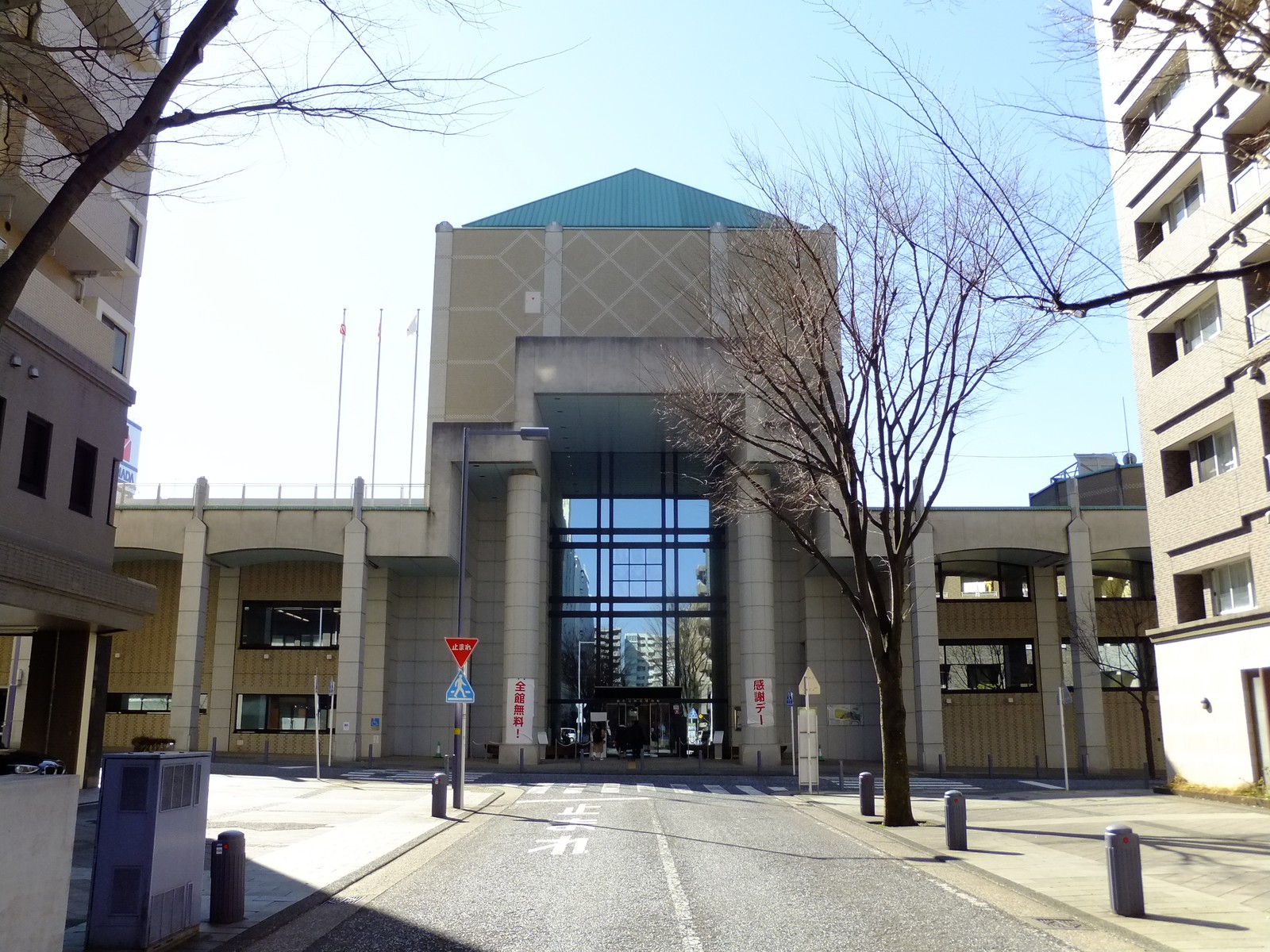 横浜市歴史博物館の正面外観。四角錐の緑色の屋根と菱形模様の外壁を持つ建物で、柱に挟まれたガラス張りの玄関が奥に見える