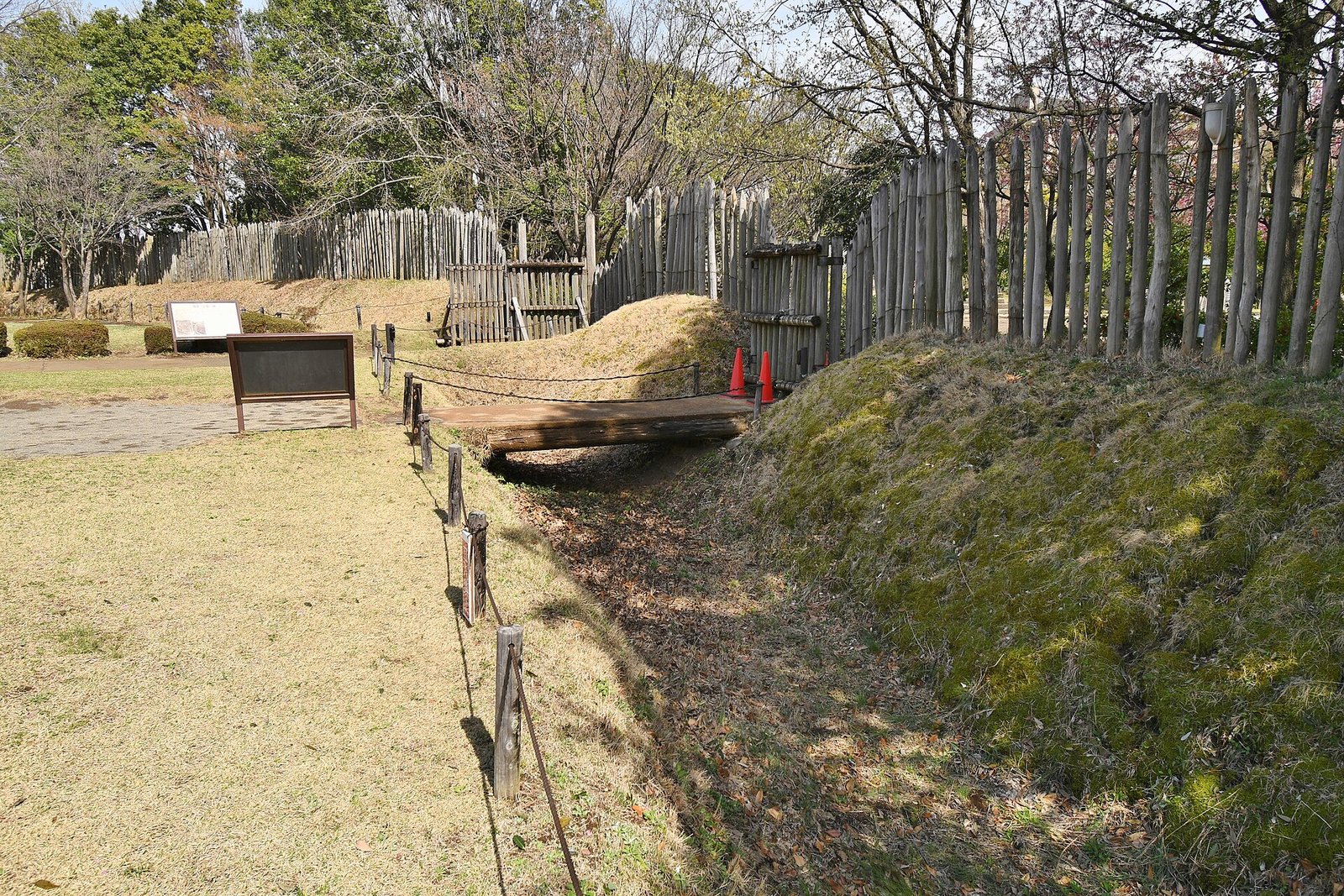 木の柵に囲まれた濠と、その上に架かる木橋