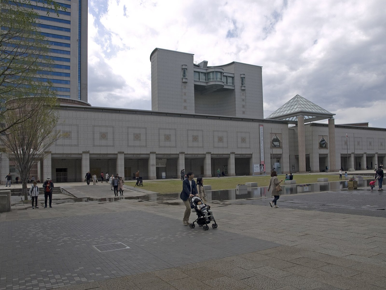 北西側から見た横浜美術館の外観。ガラス張りの塔の背後に高層ビルが並ぶ