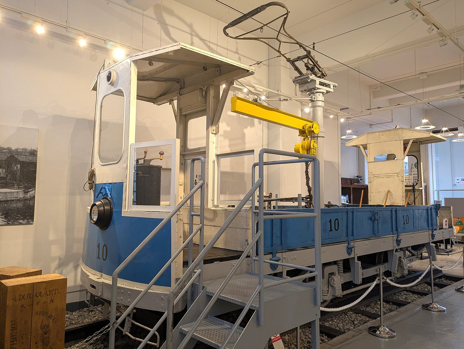 横浜市電保存館の多目的コーナーに展示されている青色の電動貨車10。階段付きの台車に載る