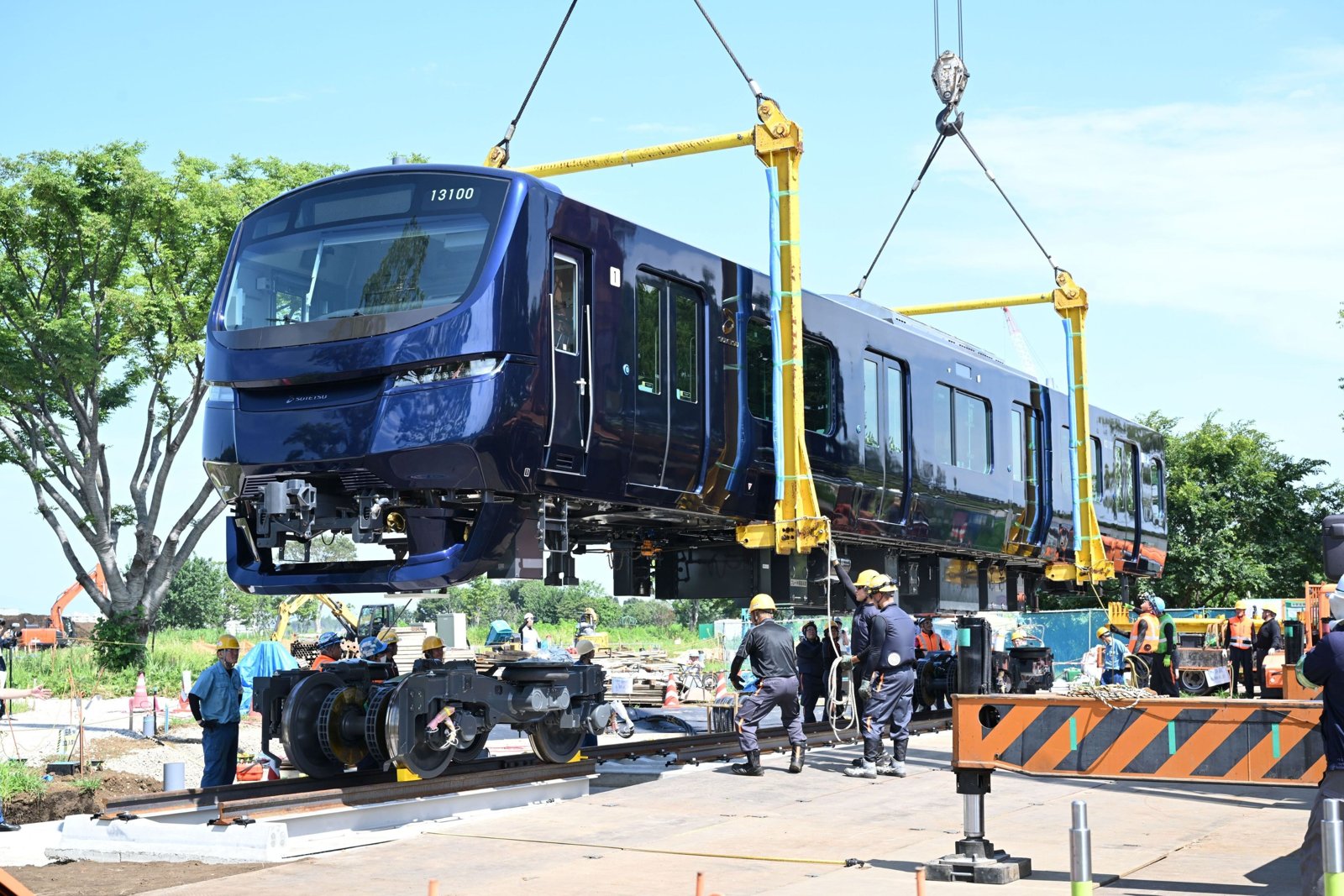 クレーンで吊り上げられ、会場内の線路に降ろされる相鉄13000系13100号車。ネイビーブルーの先頭車