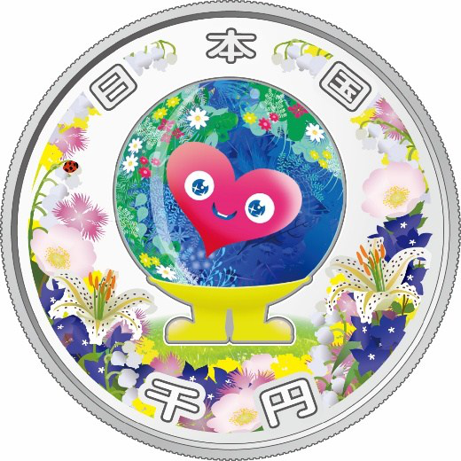 記念貨幣の表面。中央にトゥンクトゥンク、その周りに草花、上に「日本国」、下に「千円」の文字
